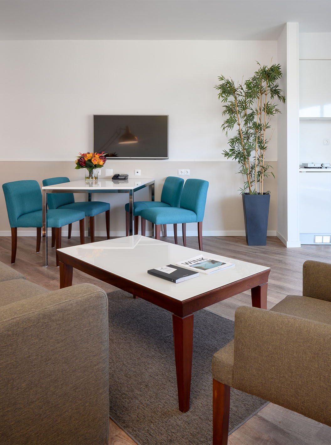 Die Deluxe Suite im Pestana Cascais hat ein Wohnzimmer mit Sofa, Couchtisch, Essbereich und TV