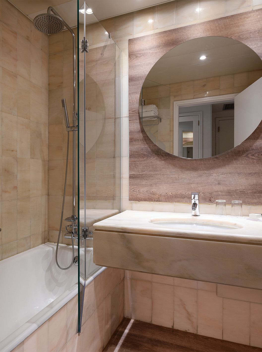 Die Deluxe Suite mit Meerblick im Pestana Cascais hat ein Badezimmer mit Spiegel, Waschbecken und Dusche