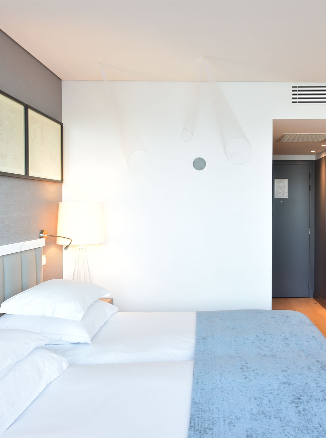 Das Double Art District Zimmer im Pestana Cidadela Cascais hat einen kleinen Flur, zwei Betten und eine Kunstwand