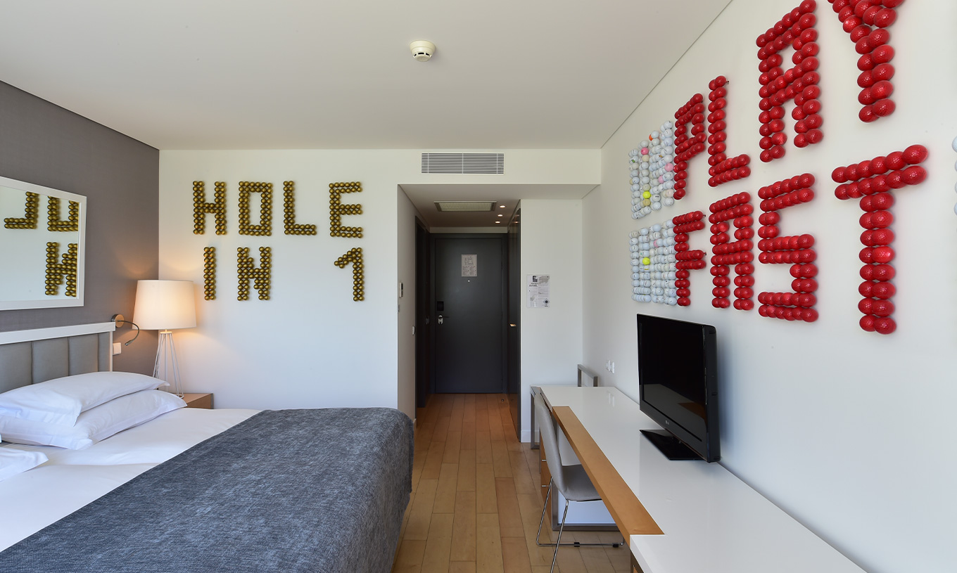 Das Superior Zimmer mit Balkon im Pestana Cidadela Cascais hat einen Flur, Fernseher und Kunst an zwei Wänden