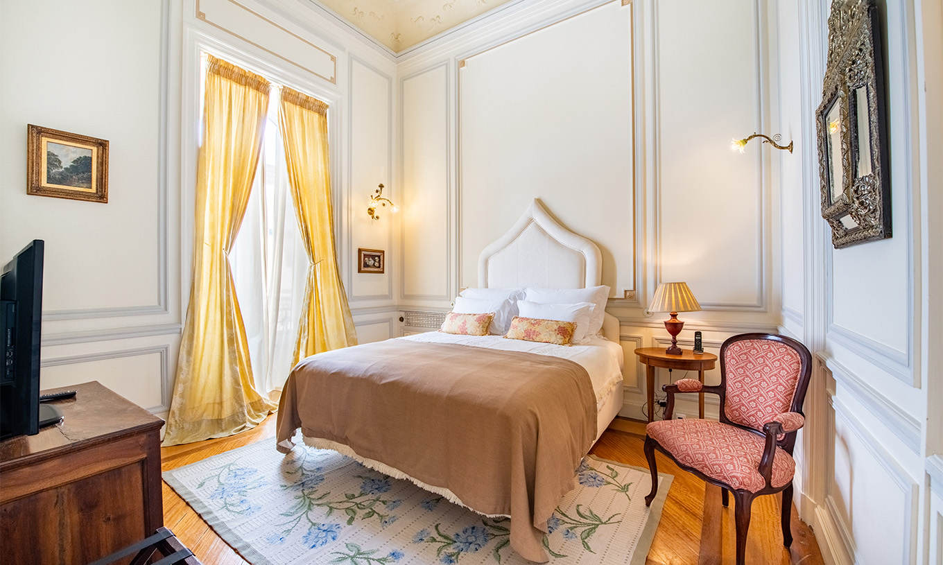 Die D. Amélia Suite im Pestana Palace Lisboa hat ein Doppelbett, Holz-Nachttisch und Fenster