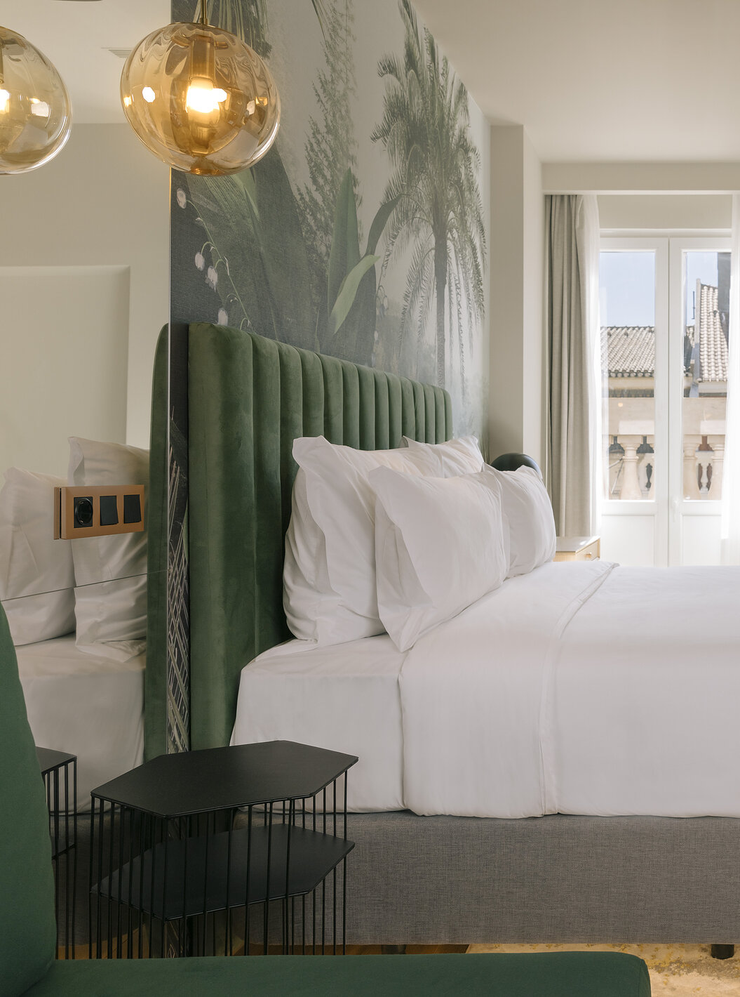 Das Superior Plus Zimmer im Pestana Rua Augusta Lisboa verfügt über ein Doppelbett, eine Palmentapete und ein Fenster