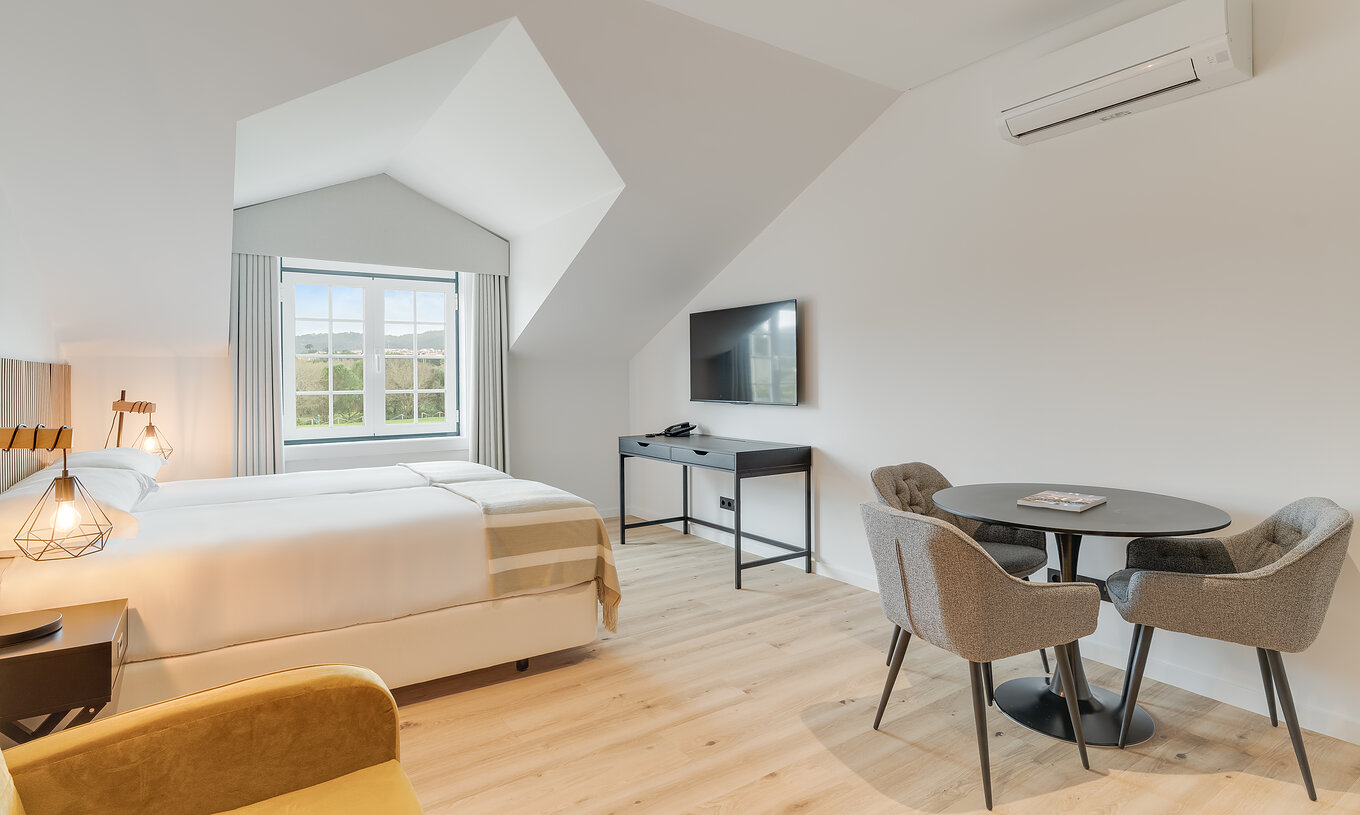 Das Familienzimmer im Clubhaus Pestana Sintra Golf hat zwei Betten und einen Tisch mit Stühlen