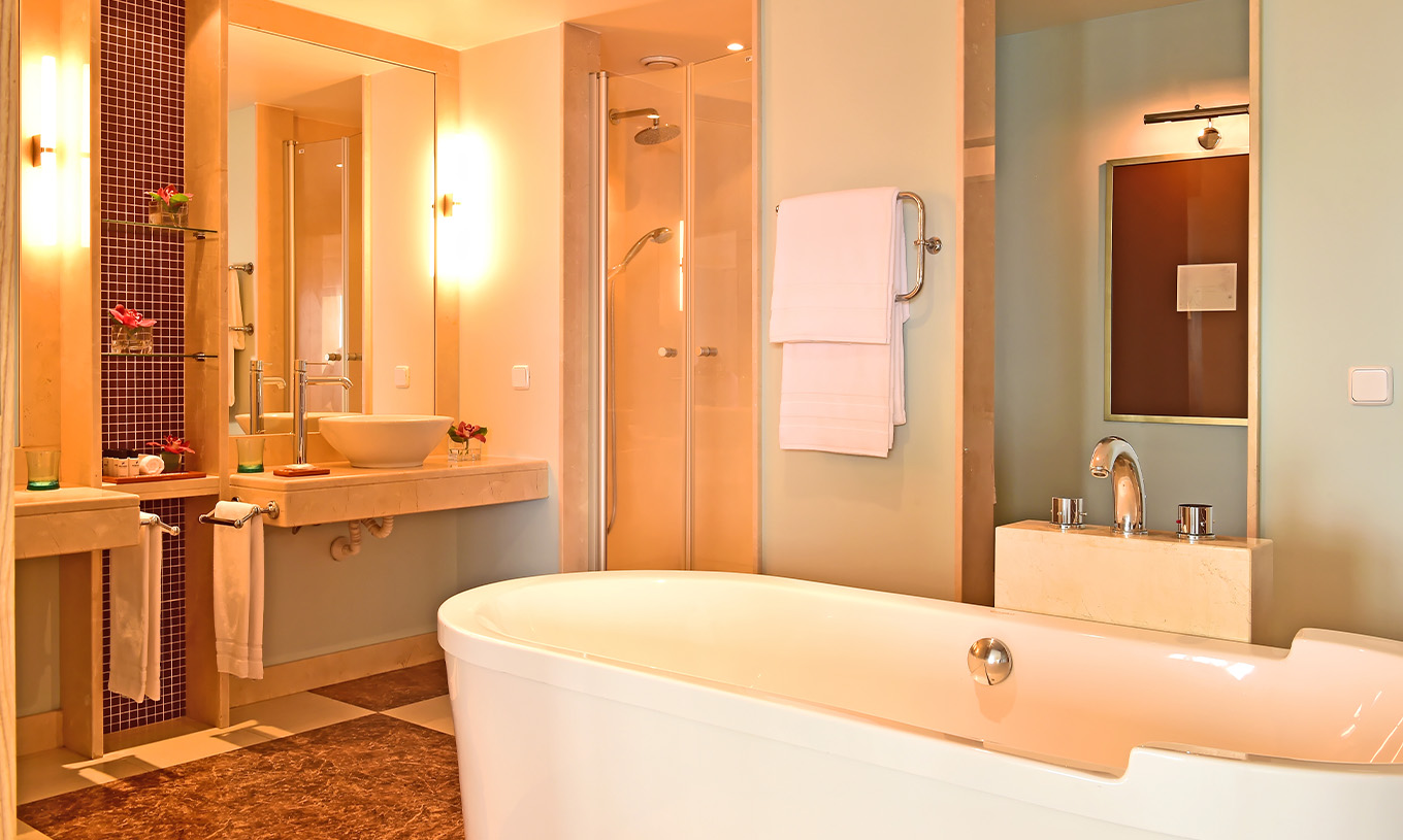Die Junior Suite im Pestana Carlton Madeira hat ein Bad mit Badewanne, Waschbecken und Dekorationselementen