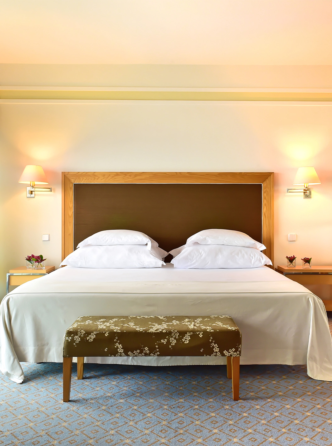 Die Junior Suite im Pestana Carlton Madeira hat ein Doppelbett mit einer Fußbank und einen Schrank mit Spiegeln