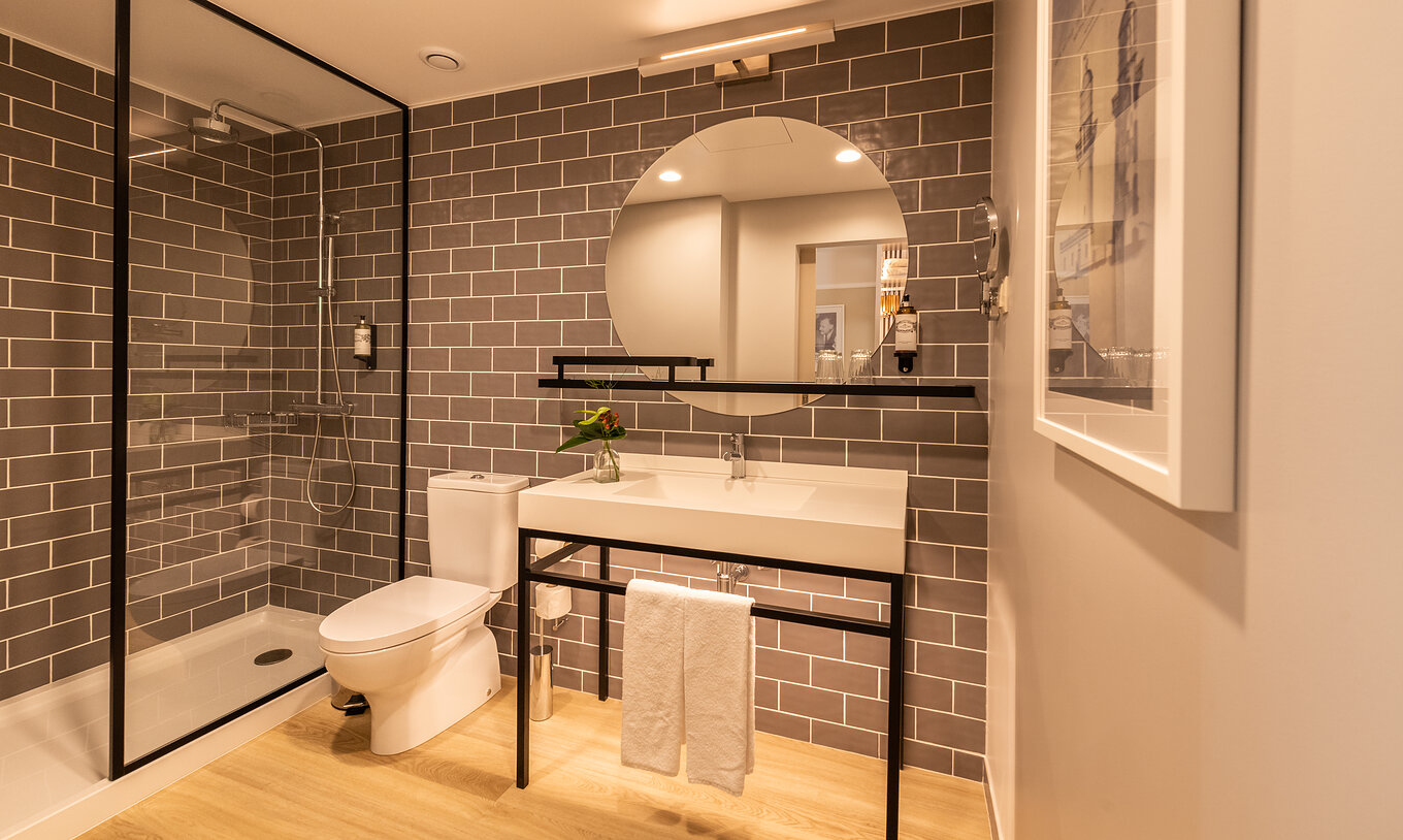 Das Superior Familien Zimmer im Pestana Fisherman hat Bad mit Dusche, WC und runden Spiegel
