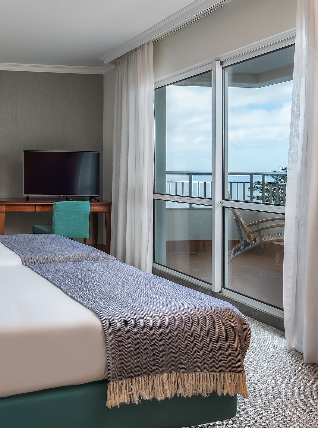 Die Standard Suite mit Meerblick im Pestana Grand hat zwei Einzelbetten, Fernseher und Schreibtisch