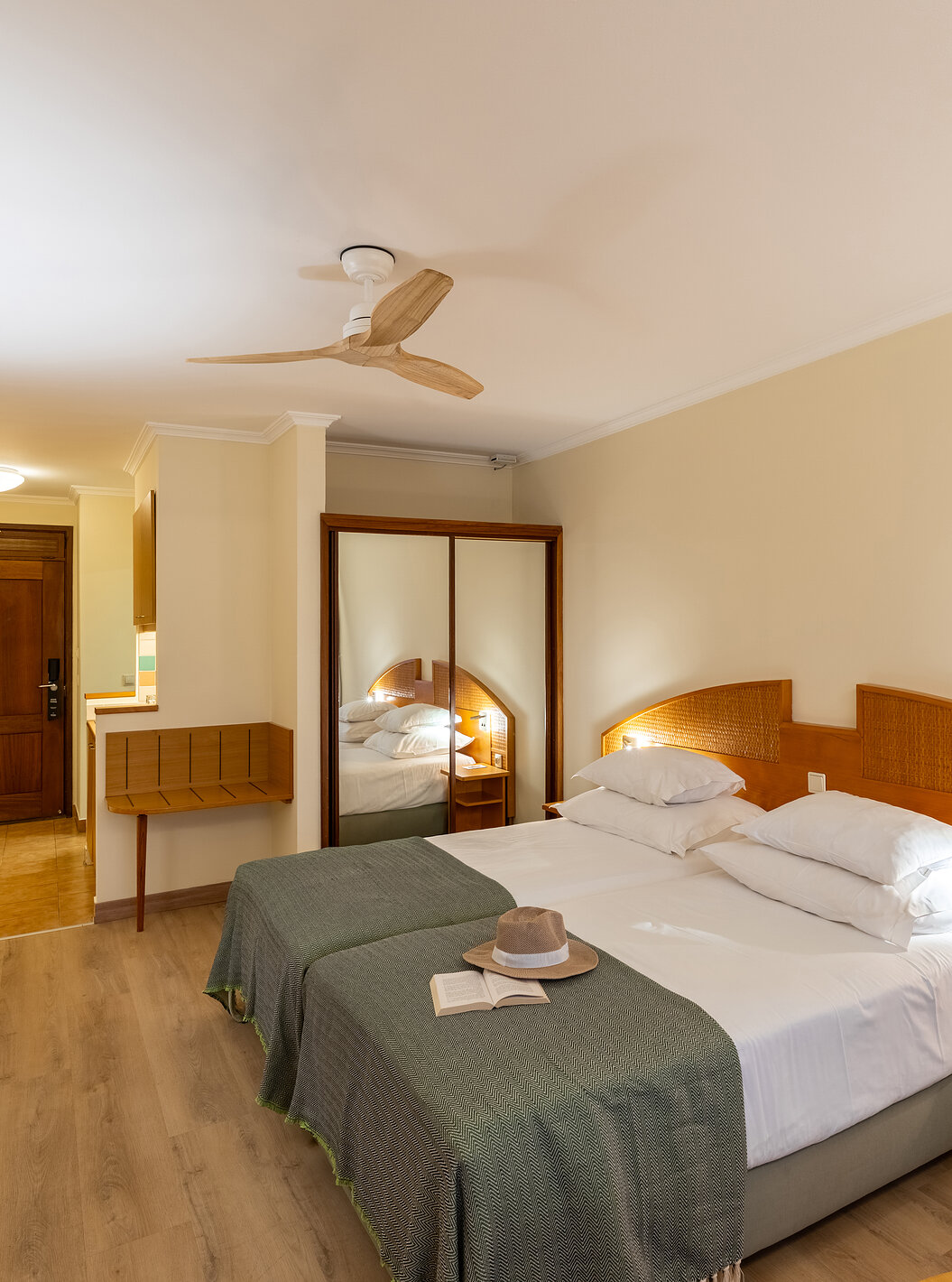 Das Classic Pool View im Pestana Ocean Bay All Inclusive verfügt über ein Doppelbett mit einer grünen Tagesdecke