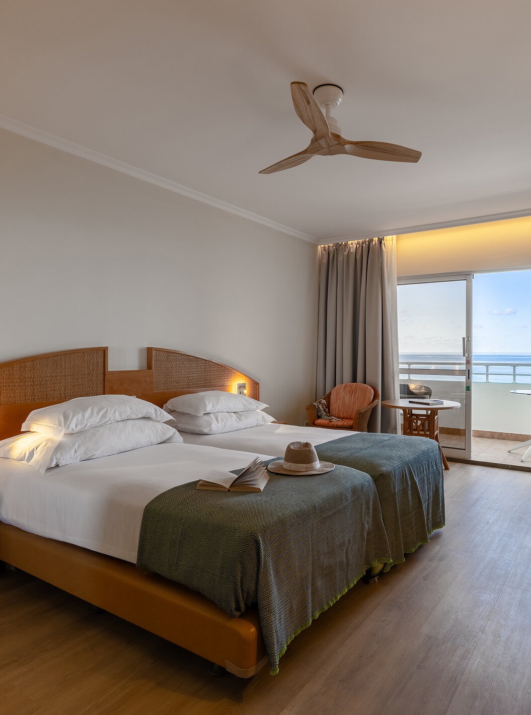Das Classic Sea View im Pestana Ocean Bay All Inclusive verfügt über ein Doppelbett zwei Stühle und einen Balkon mit Aussicht