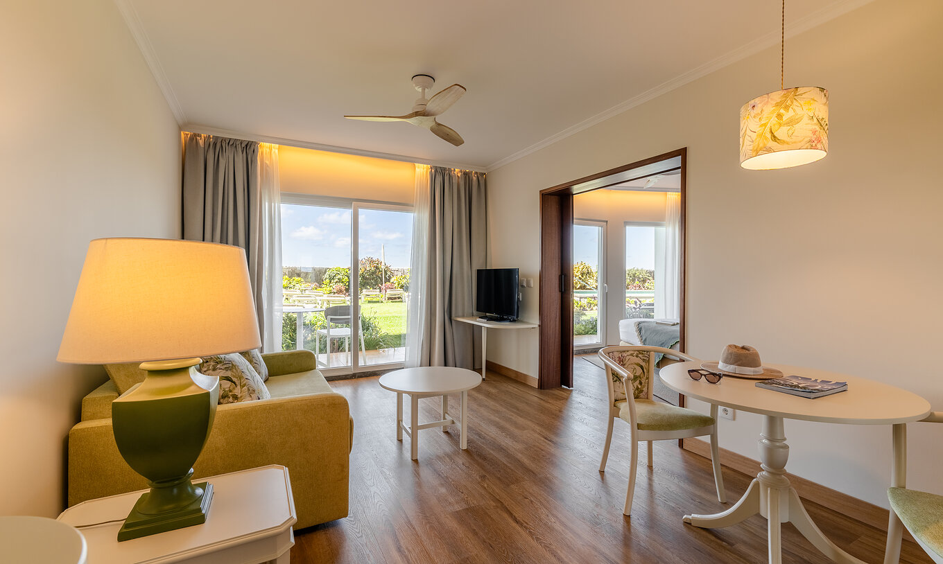 Die Junior Suite Sea View im Pestana Ocean Bay All Inclusive verfügt über ein Wohnzimmer mit Sofa, Couchtisch und Esstisch