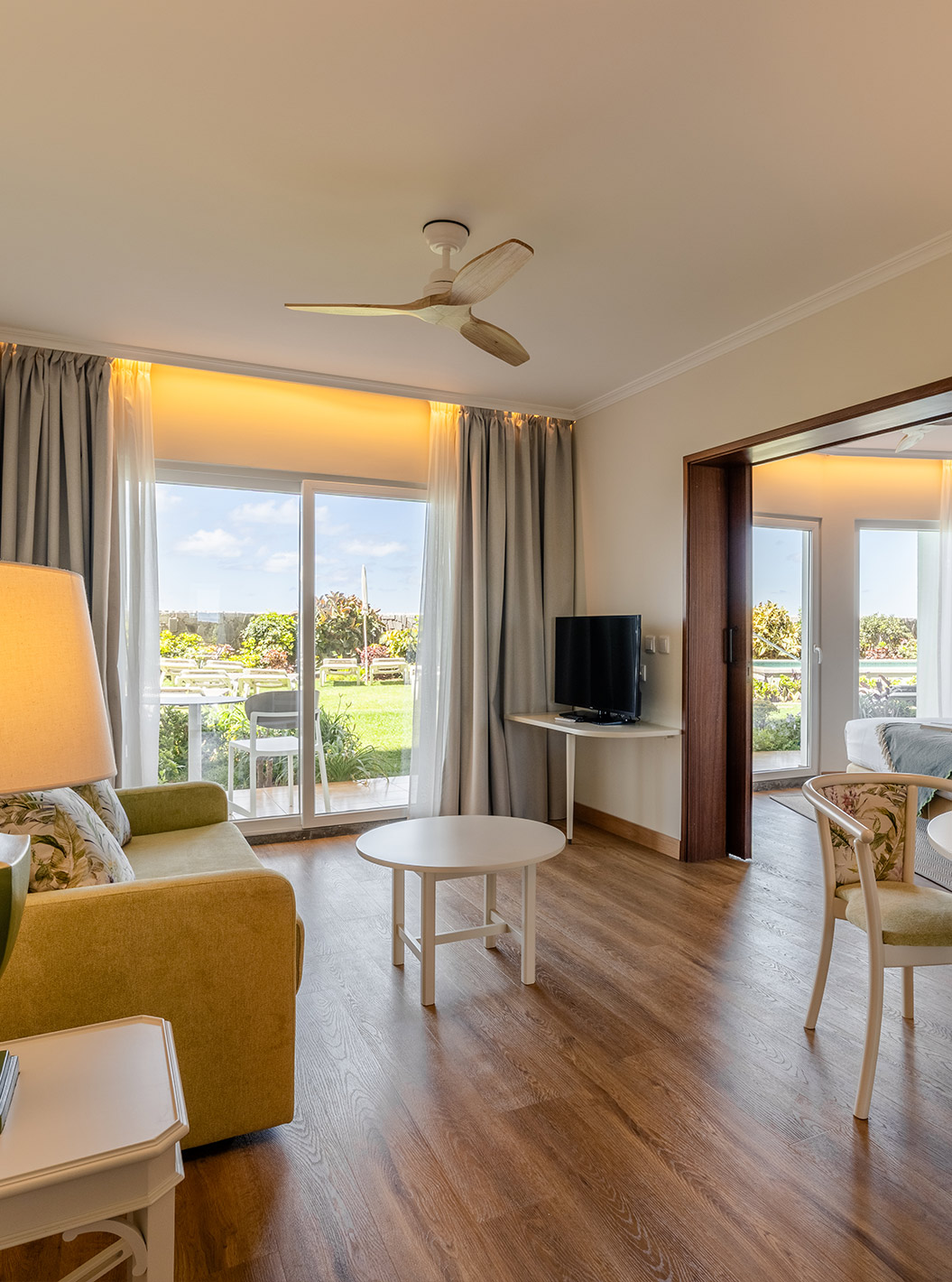 Die Junior Suite Sea View im Pestana Ocean Bay All Inclusive verfügt über ein Wohnzimmer mit Sofa, Couchtisch und Esstisch