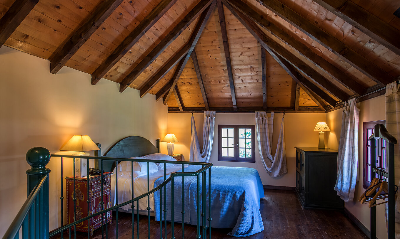 Die Duplex Villen haben ein Doppelbett mit Holzdecke, Nachttische und eine Holzkommode 