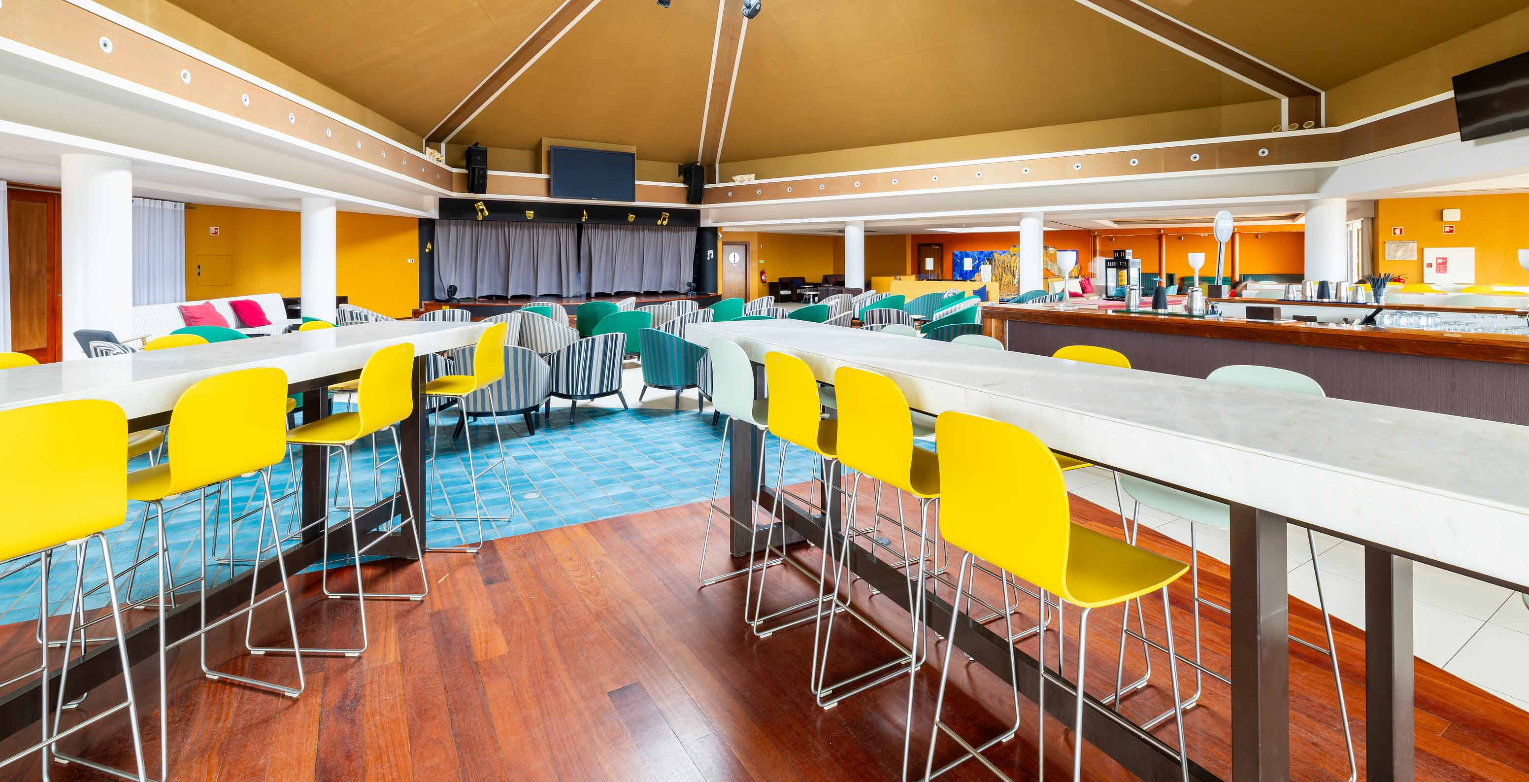 Die Sunset Bar im 5-Sterne-Resort auf Porto Santo hat hohe Tische mit gelben und weißen Hockern.