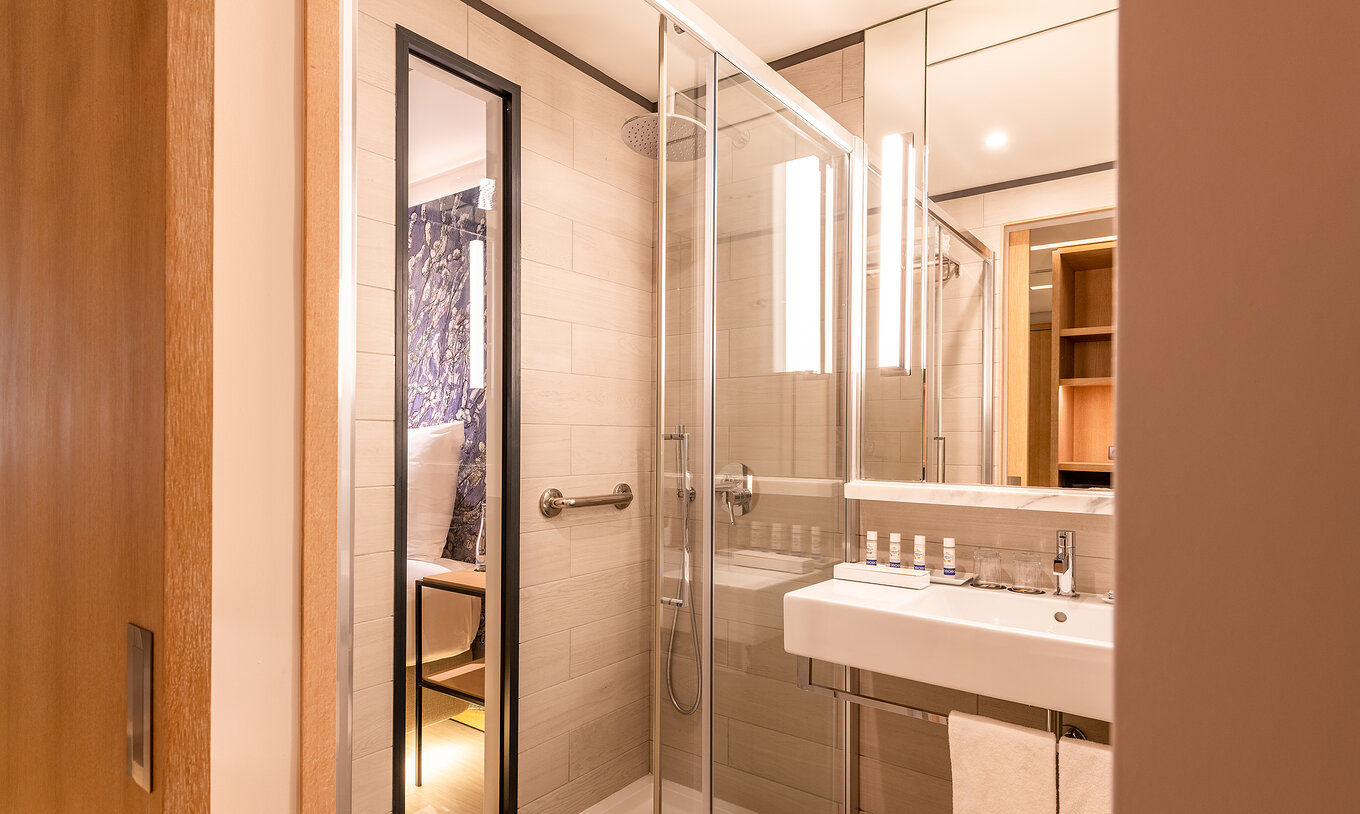 Das Deluxe River View Zimmer im Pestana Douro Riverside hat ein Bad mit Waschbecken, Spiegel und Dusche