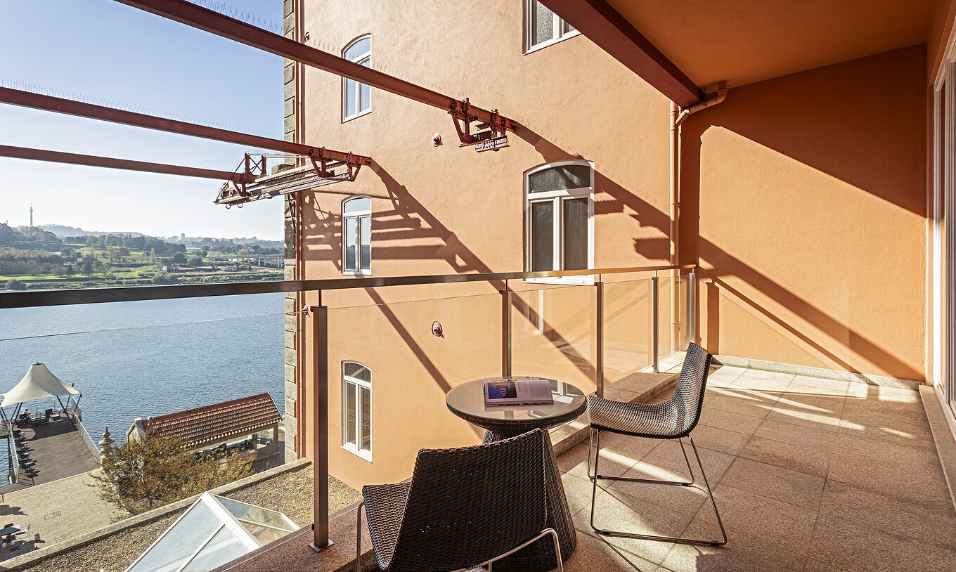 Die Suite Balcony verfügt über einen Balkon mit Tisch, zwei Stühlen und Blick auf den Fluss Douro