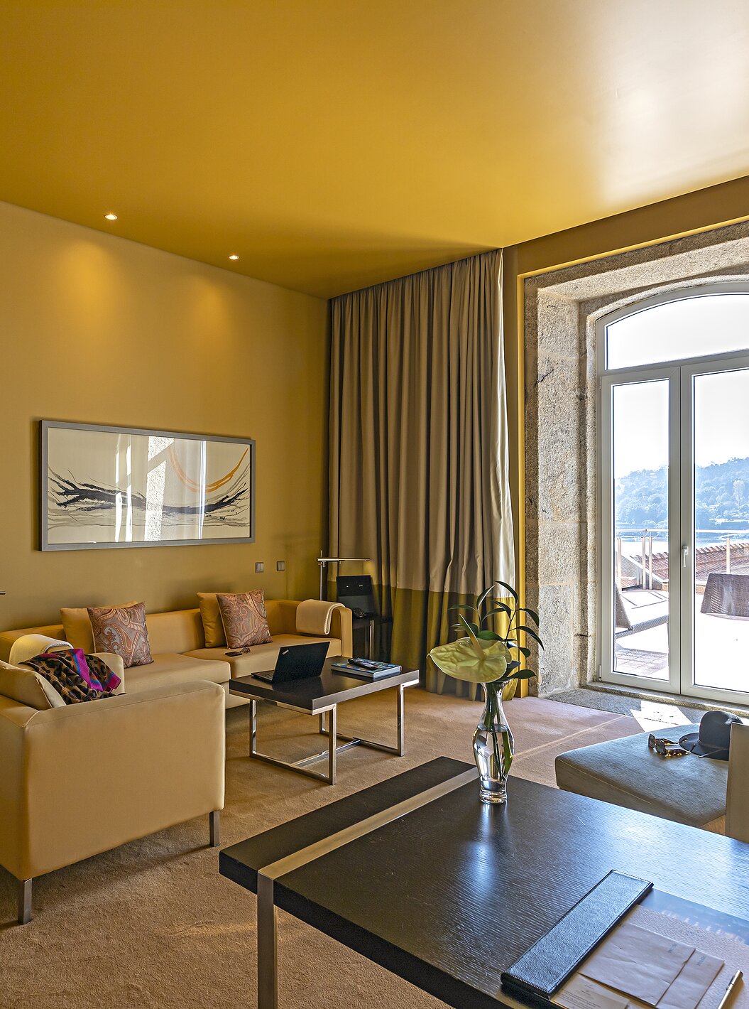 Die Suite Nasoni verfügt über ein Wohnzimmer mit sofas, Schreibtisch und einem Steinfenster zum Balkon