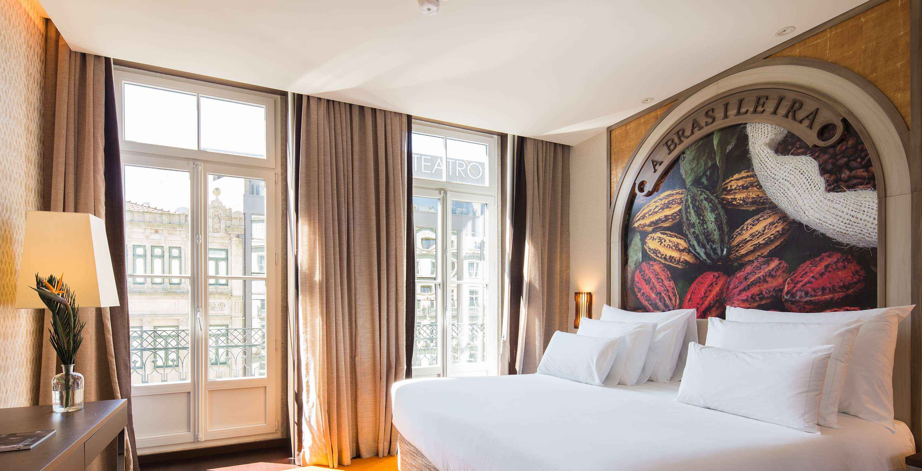 Classic Zimmer mit französischem Balkonfenster im Pestana A Brasileira Porto mit hellem Bett und hohen Fenstern