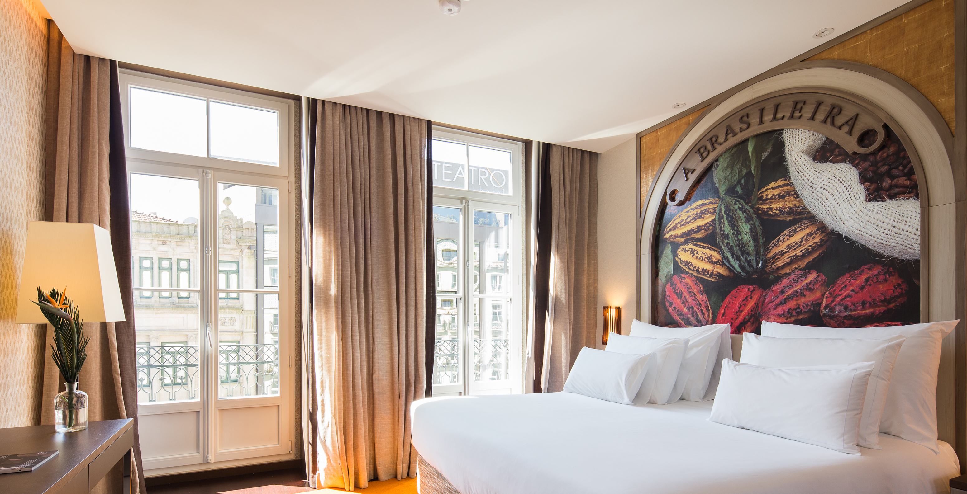 Das Deluxe Superior Zimmer hat zwei Fenster mit kleinem Balkon und Stadtblick 
