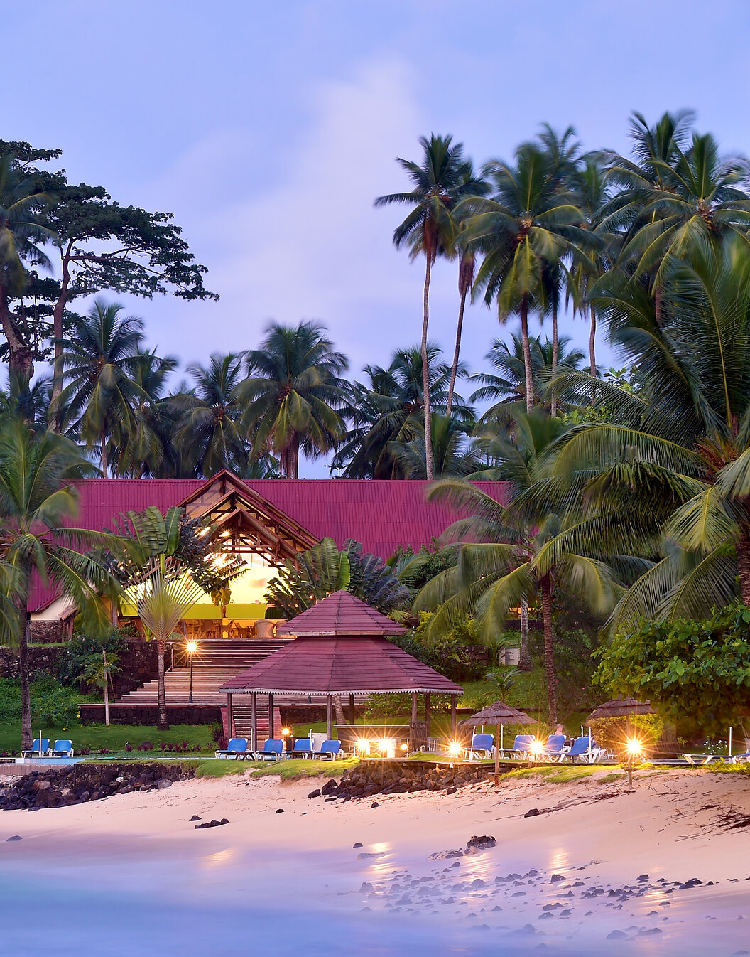 Strand und Gebäude mit Liegen und Palmen des Pestana Equador, Hotel auf Ilhéu das Rolas, São Tomé