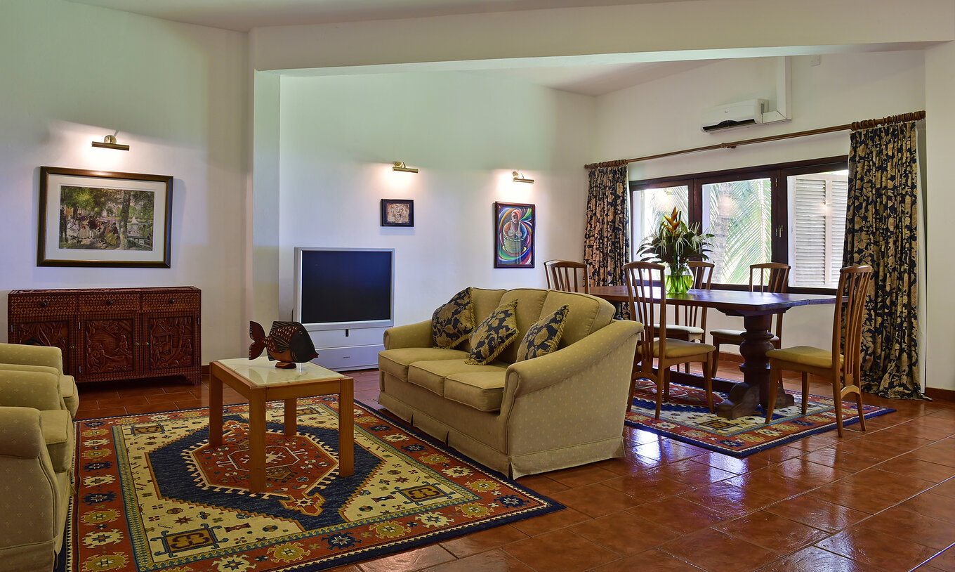 Die Präsidentensuite im Pestana Miramar São Tomé hat ein Wohnzimmer mit drei Sofas, Esstisch und Fernseher