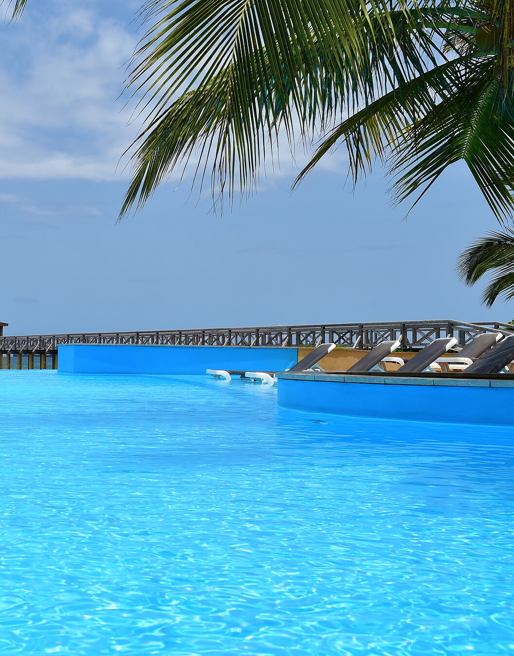 Paradiesischer Pool des Pestana São Tomé, der sich nahtlos in das kristallklare Meer erstreckt