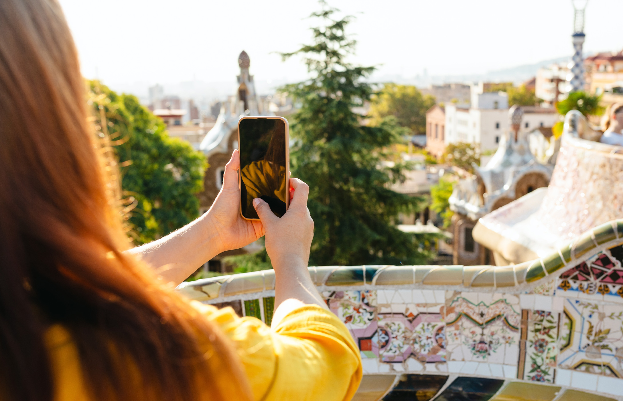 Person, die die Aussicht auf Barcelona im berühmten Park Güell mit ihrem Handy fotografiert