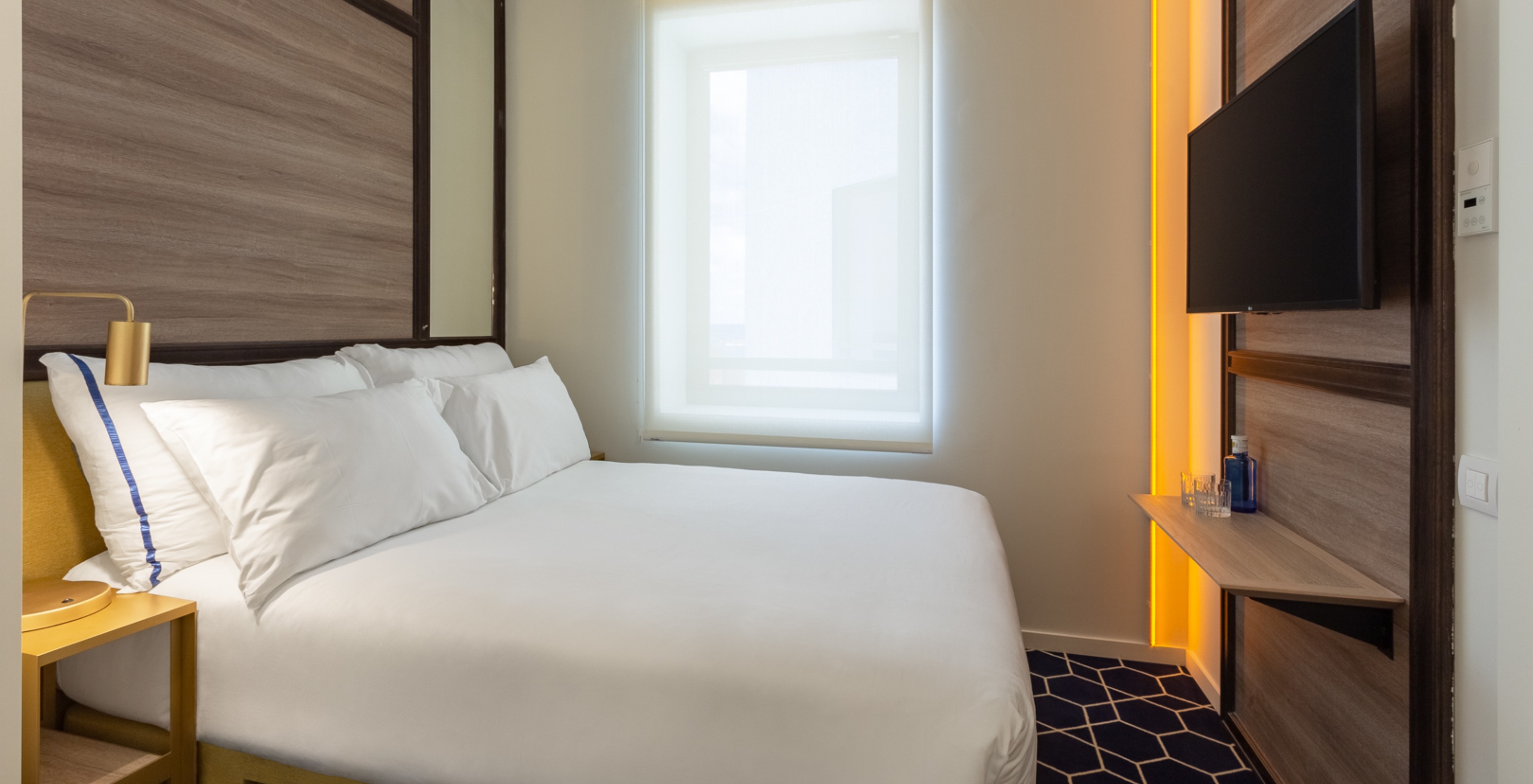 Das Kleine Doppelzimmer im Pestana CR7 Gran Vía Madrid hat ein Doppelbett, ein Fenster und einen gelben Nachttisch