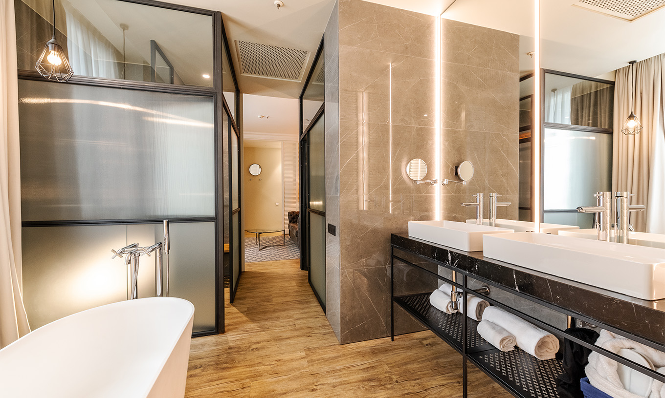 Die Suite im Pestana Plaza Mayor Madrid hat ein großes Bad mit zwei Waschbecken, Spiegel und Badewanne