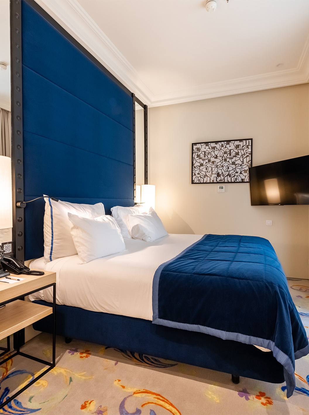 Die Suite im Pestana Plaza Mayor Madrid hat ein Doppelbett, Nachttisch, Fernseher an der Wand und ein Fenster