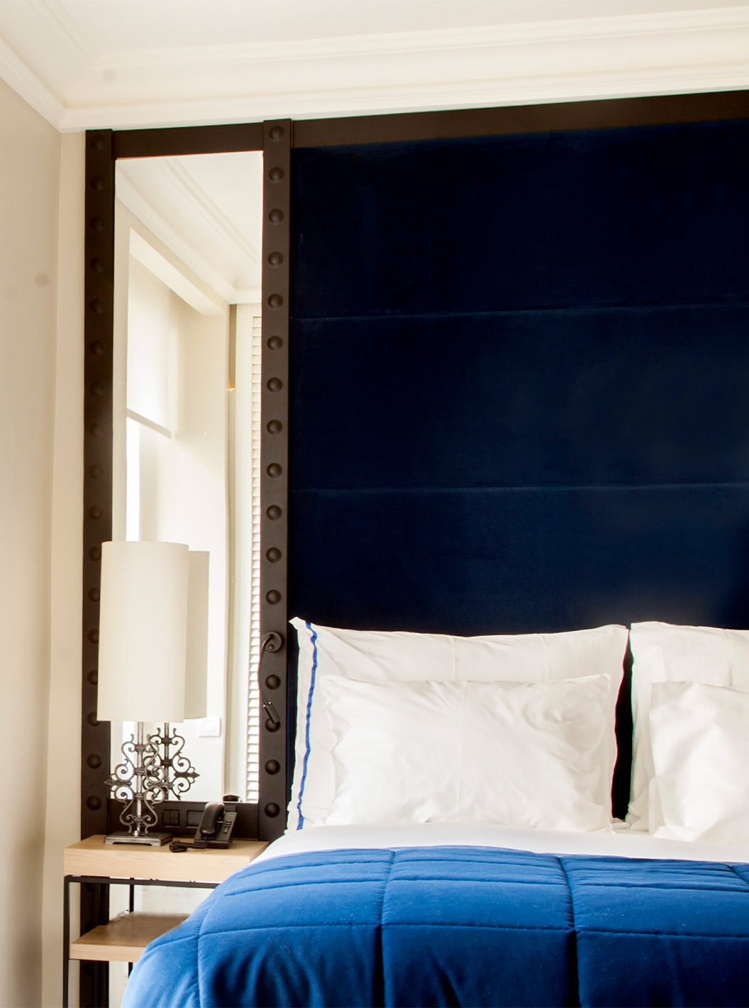 Das Superior Zimmer im Pestana Plaza Mayor Madrid hat ein Doppelbett mit blauer Kopfstütze und Waschbecken