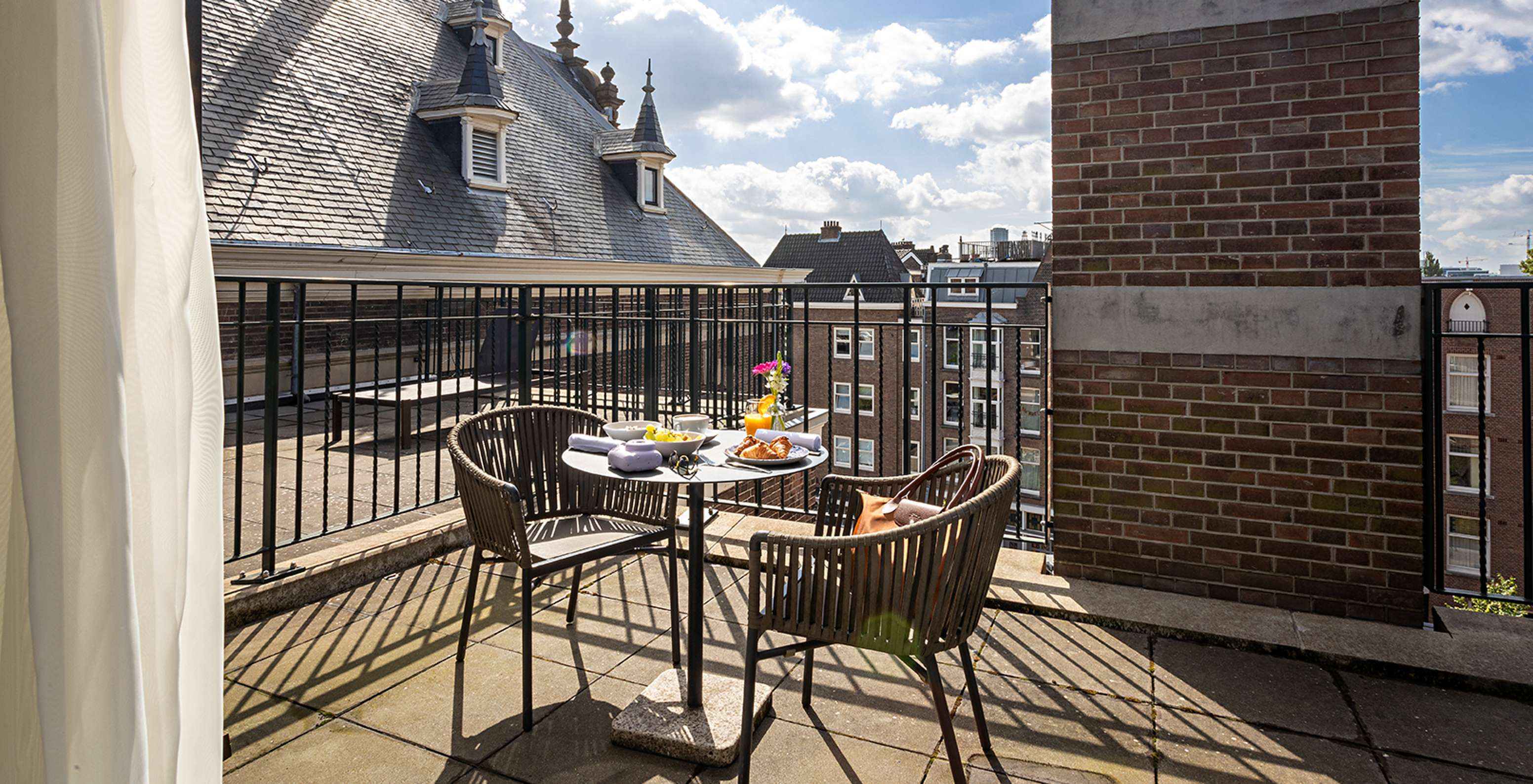 Das Superior mit Terrasse Zimmer im Pestana Amsterdam Riverside hat einen Balkon mit Tisch