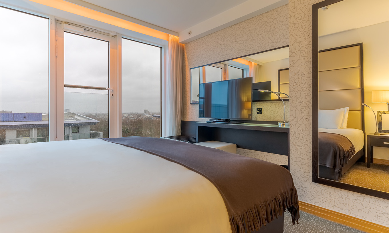 Die Executive Suite mit 1 Schlafzimmer im Pestana Chelsea Bridge hat ein Doppelbett, Schreibtisch mit Fernseher und Fenster