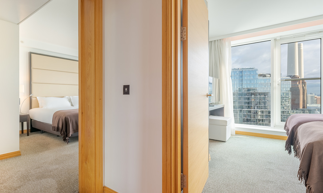 Die Signature Suite mit 2 Schlafzimmern im Pestana Chelsea Bridge hat zwei Schlafzimmer mit Doppelbett und zwei Einzelbetten