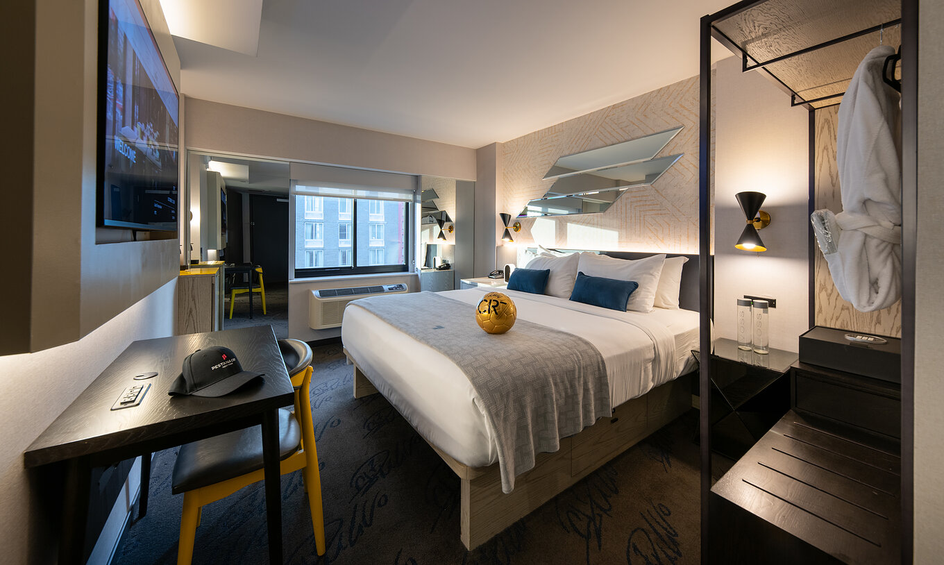 Das Deluxe King Room ADA im Pestana CR7 Times Square hat ein Doppelbett, einen Schreibtisch und einen Kleiderschrank