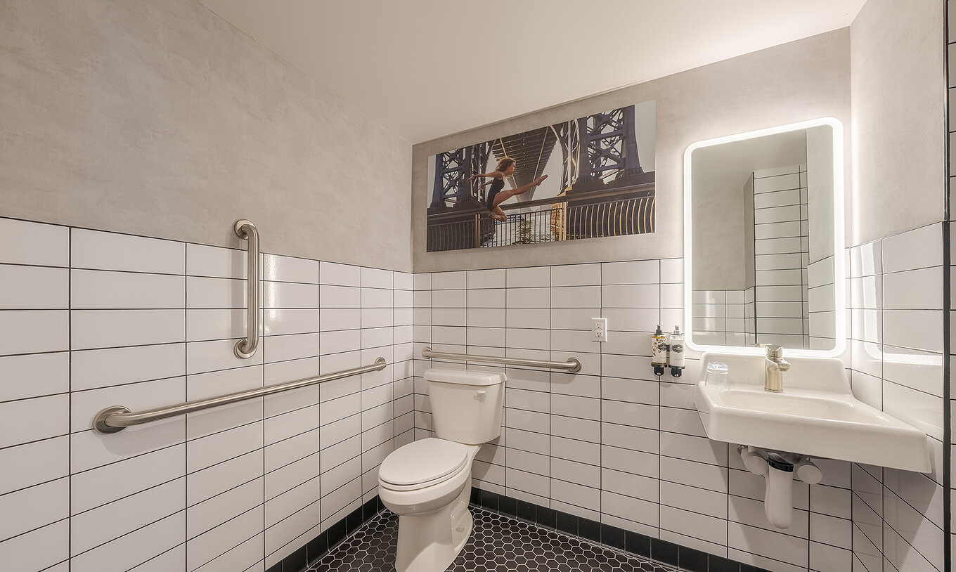 Das Comfort ADA im Pestana CR7 Times Square hat ein angepasstes Badezimmer mit Toilette, Waschbecken und Spiegel