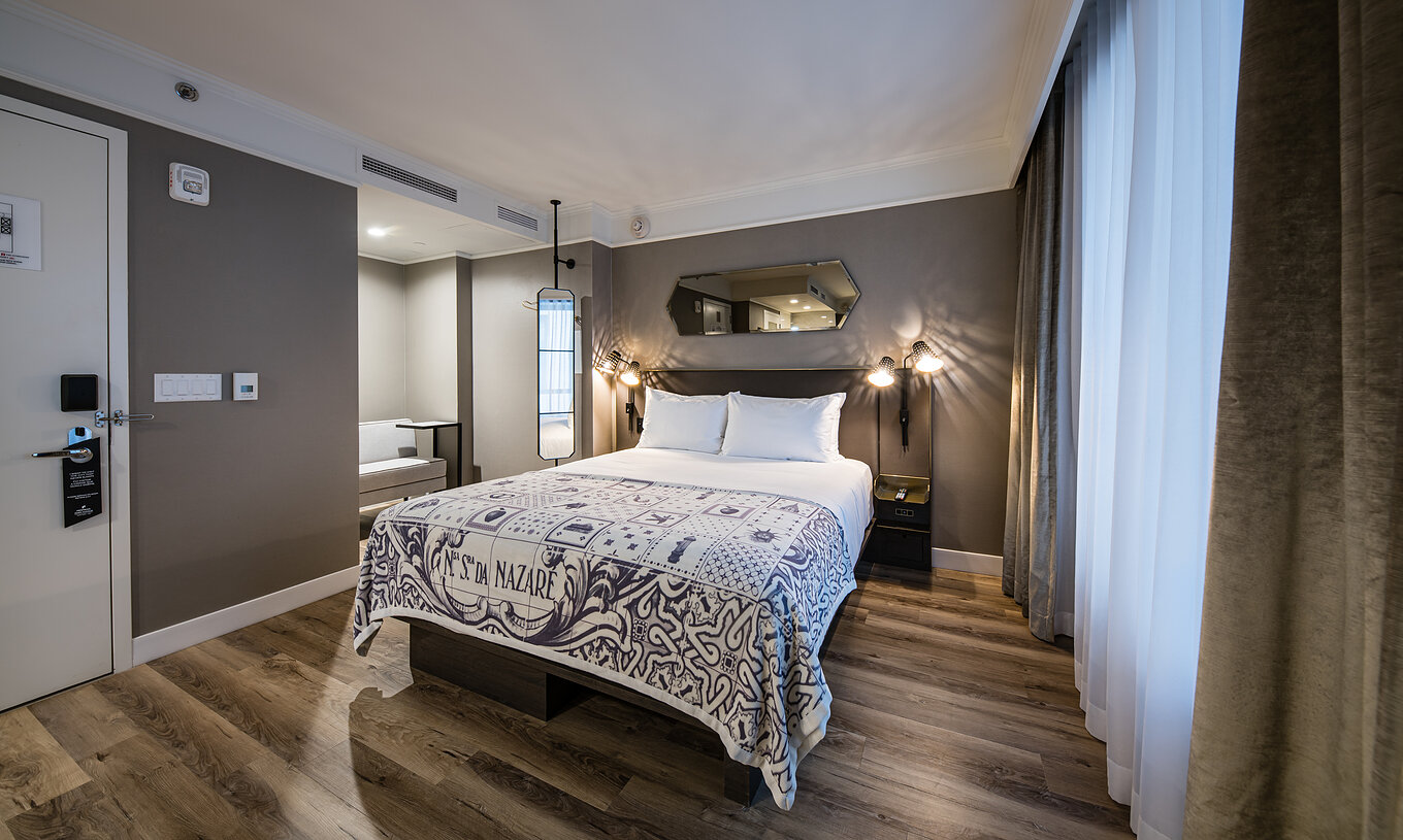Die Junior Suite - ADA im Pestana Park Avenue hat ein Doppelbett, Spiegel und Lampe