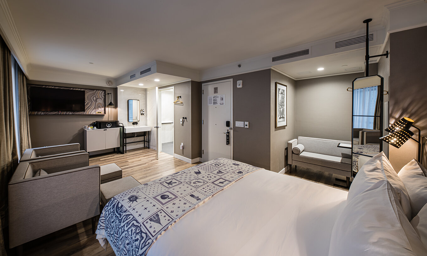 Die Junior Suite - ADA im Pestana Park Avenue hat ein Wohnzimmer mit Sofa, Sesseln, Safe und Fernseher