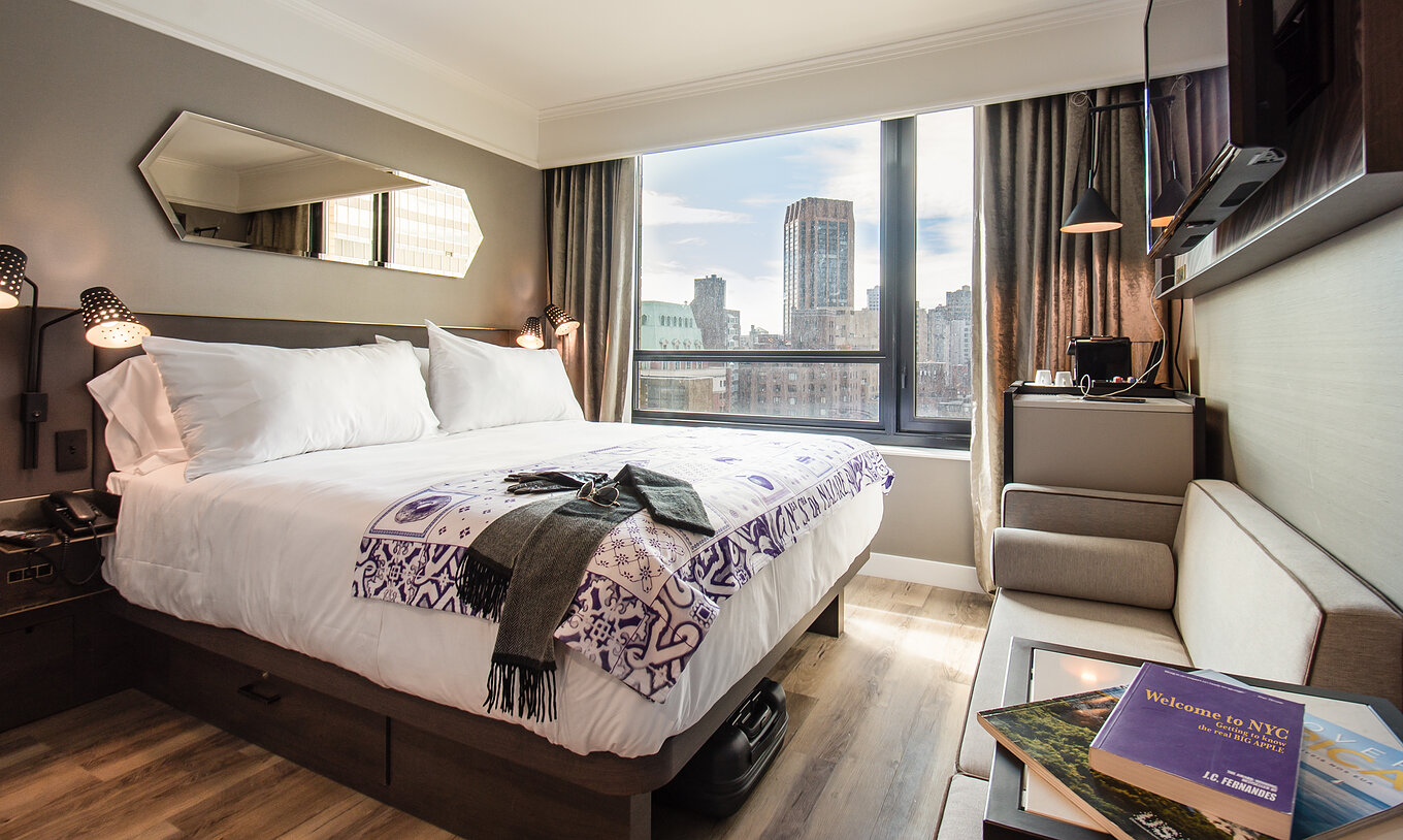 Das Superior Zimmer im Pestana Park Avenue hat ein Doppelbett, Fernseher, Spiegel und Stadtblick