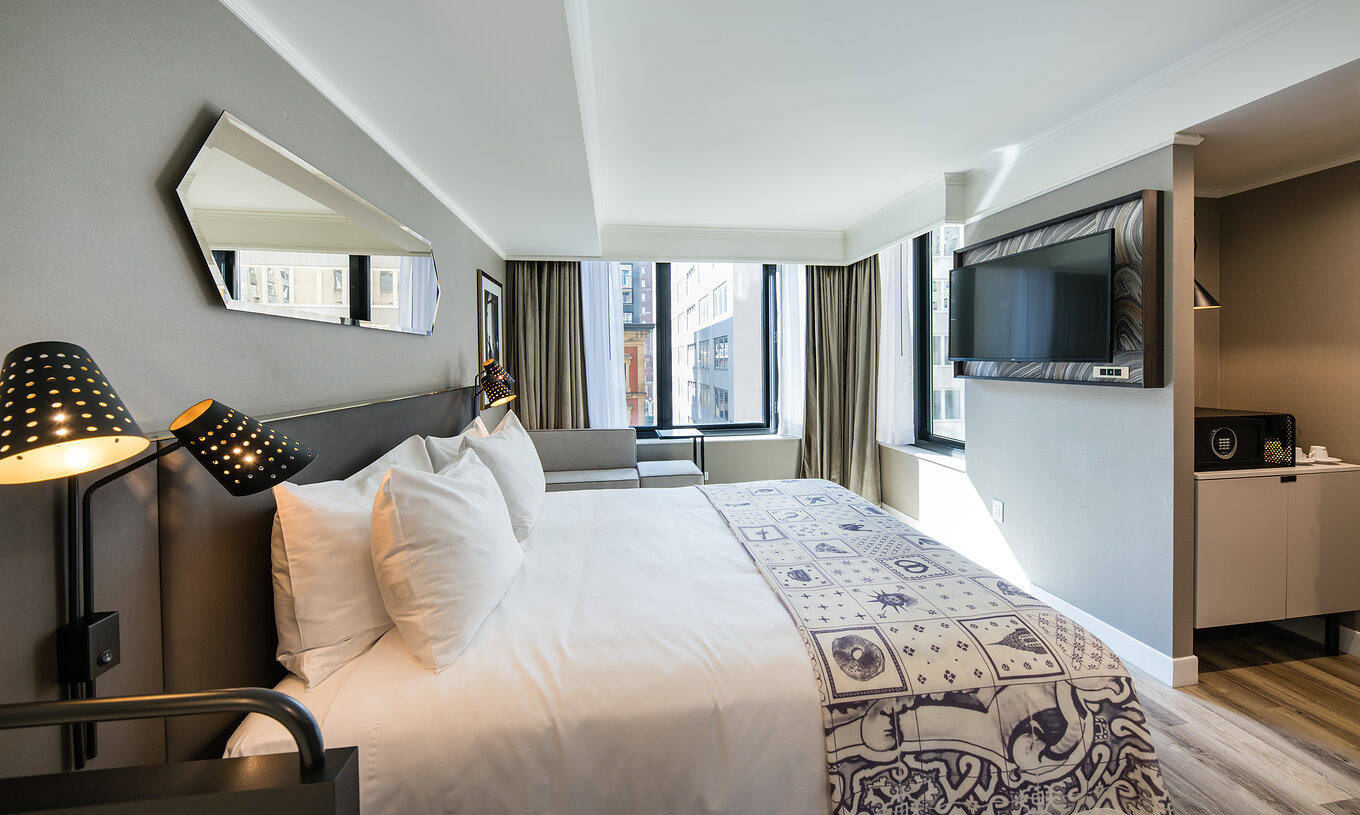 Das Superior Zimmer im Pestana Park Avenue hat ein Doppelbett, Fernseher, Spiegel und Stadtblick