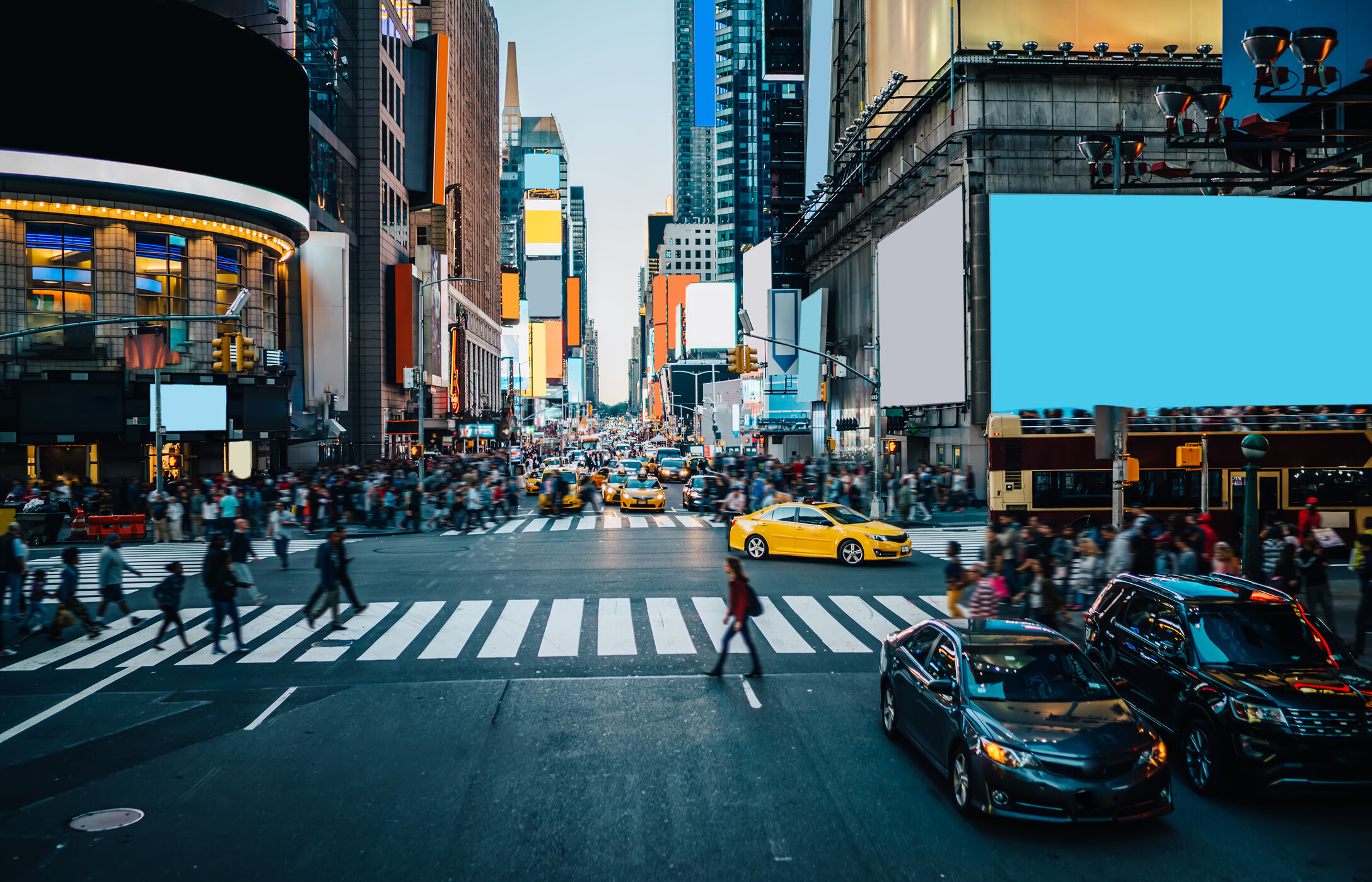 Der berühmte Times Square in New York, belebt mit Autos und Menschen, riesigen Bildschirmen und hohen Gebäuden.