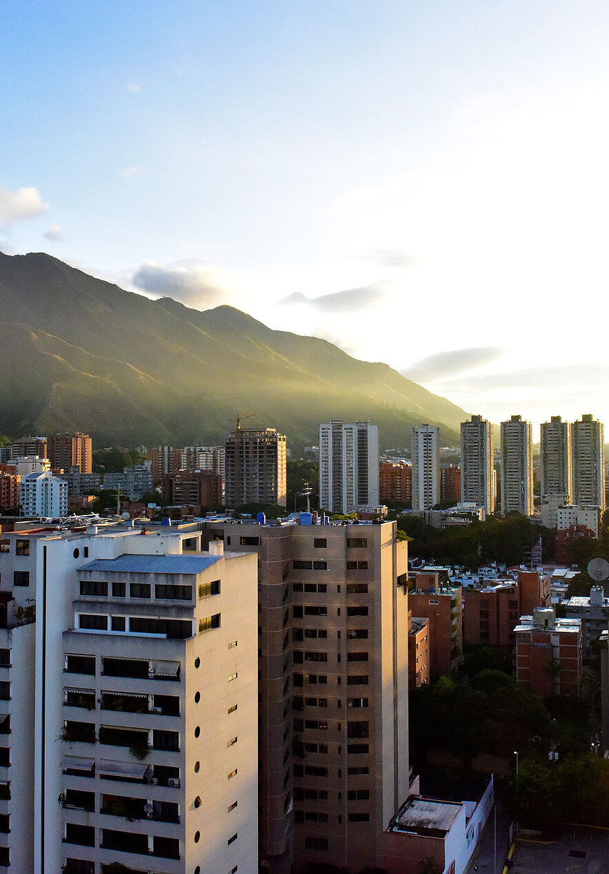 Entdecken Sie Venezuela, ein Land voller natürlicher Schönheit und lebendiger Kultur, mit hohen Gebäuden und grünen Bergen.