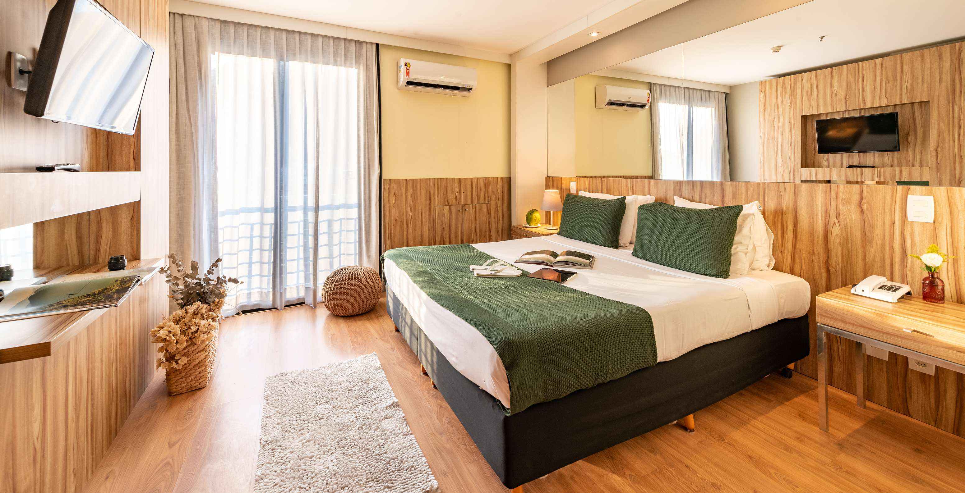 The Suite Side Sea View of Pestana Rio Atlântica has a double bed with a mirror on the headboard and a television in front