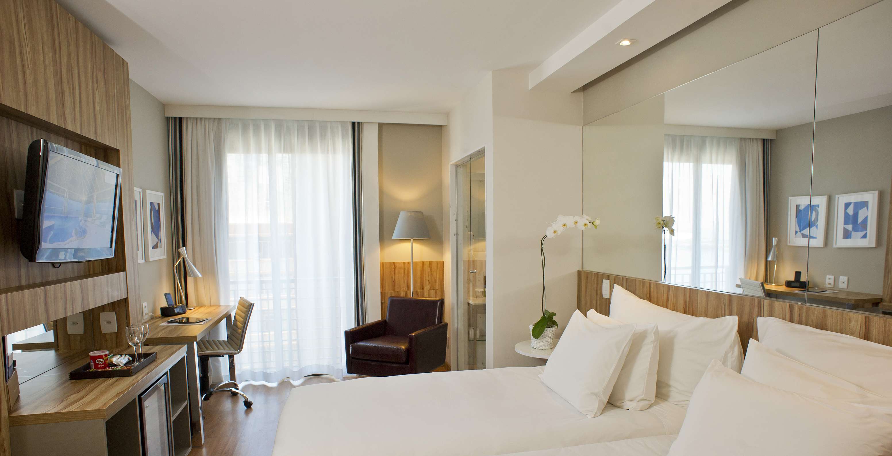 The Twin Side Sea View of Pestana Rio Atlântica has two beds with a mirror on the headboard and a television in front