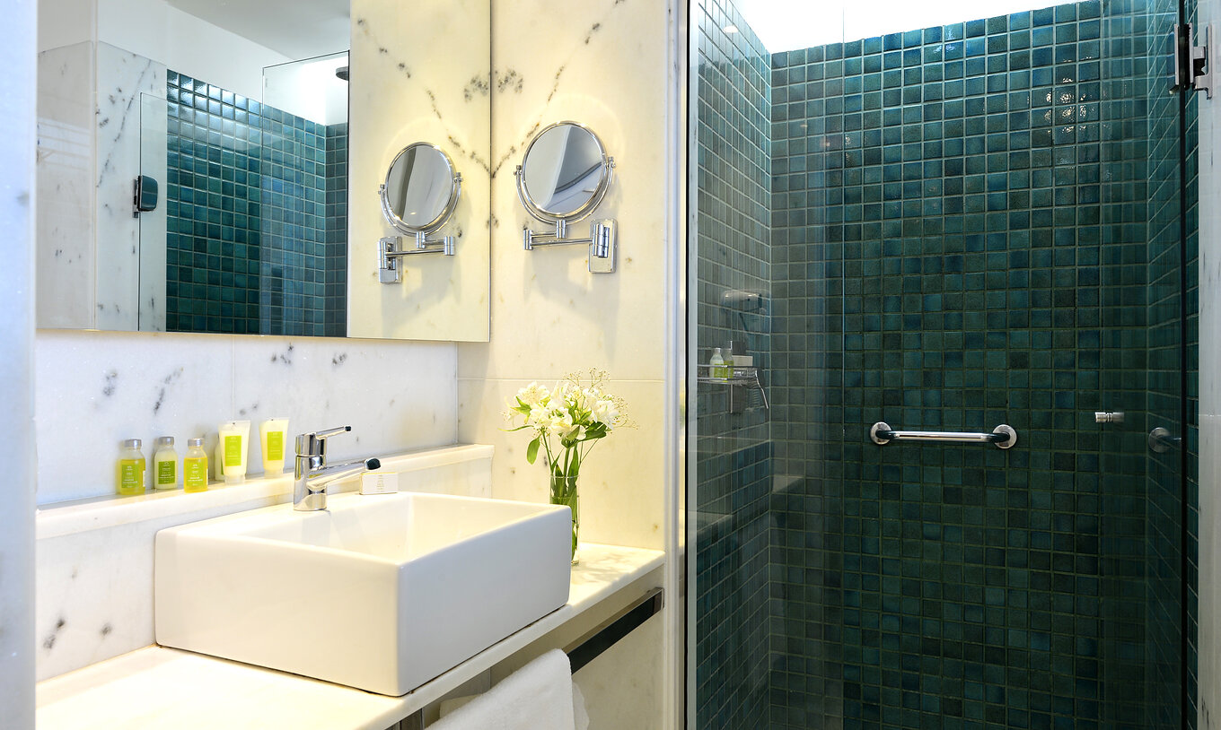 The Standard Twin Room of Pestana Rio Atlântica has a bathroom with shower, sink with mirror, and amenities