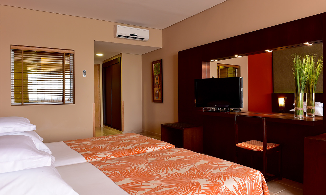 The Classic Sea View room at Pestana Tropico features two single beds, television, bedside table, and mirror