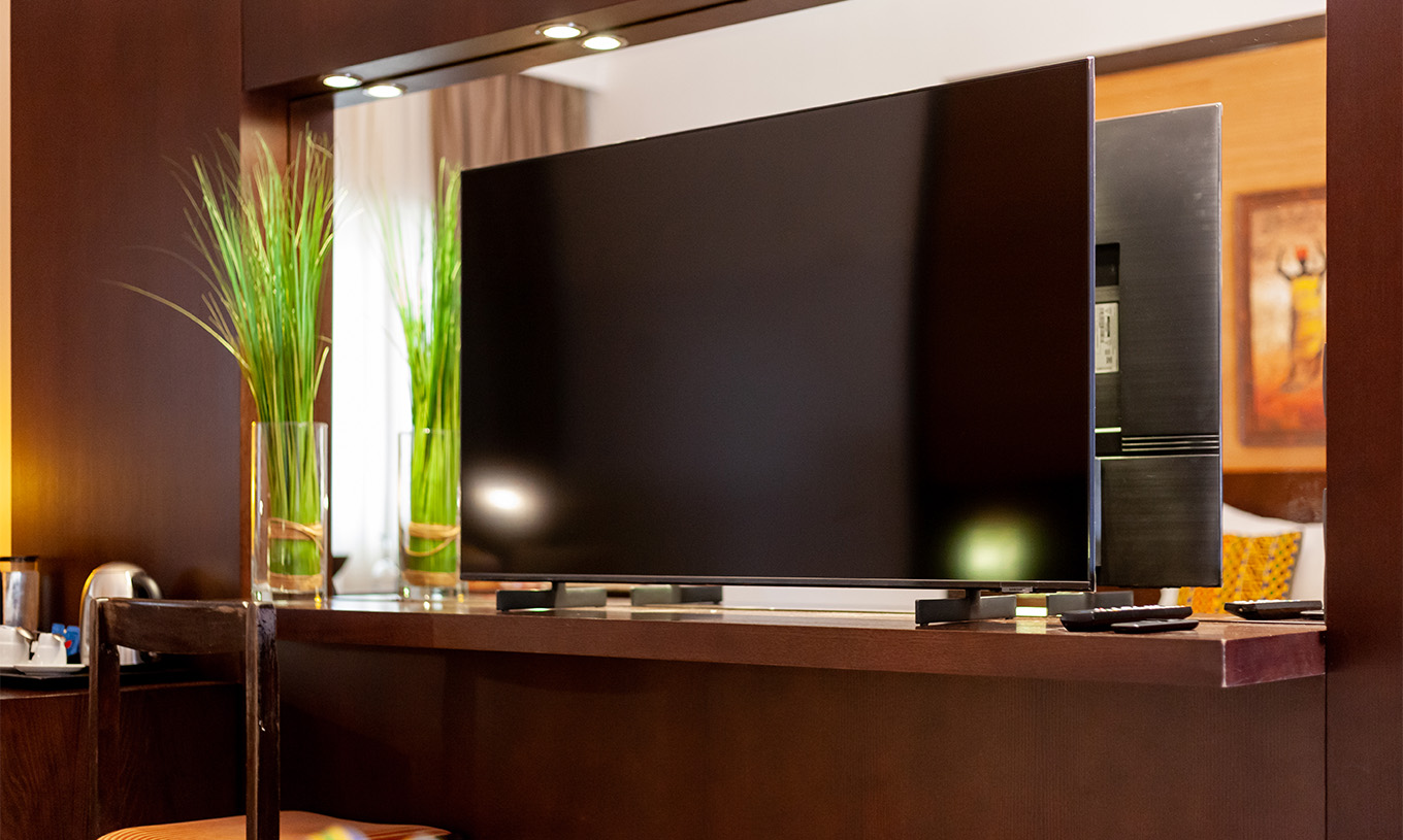 The Junior Suite at Pestana Tropico features a television, a mirror, and a chair
