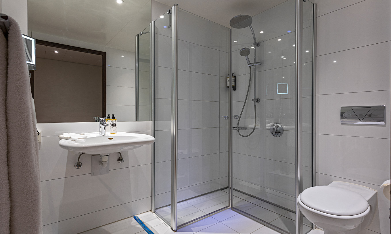 Deluxe Room with Terrace at Pestana Berlin Tiergarten has a bathroom with shower, a sink and a mirror