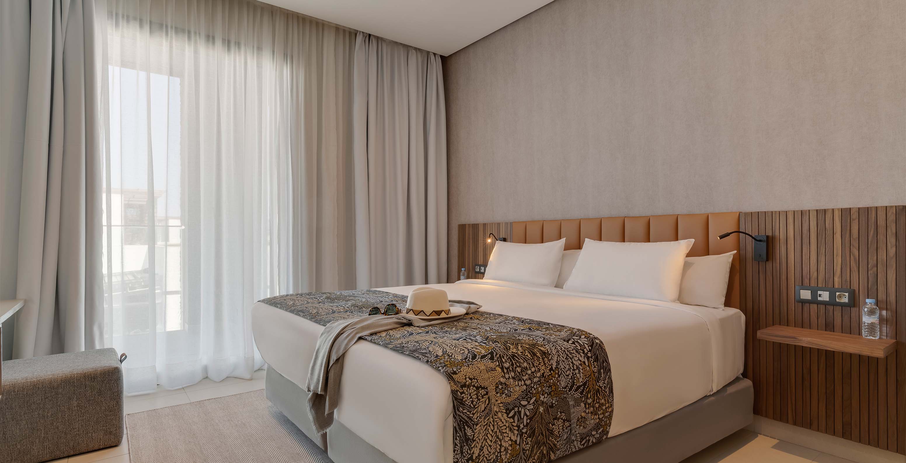 The Family Corniche Suite at Pestana Casablanca has a bedroom with a double bed and modern decor
