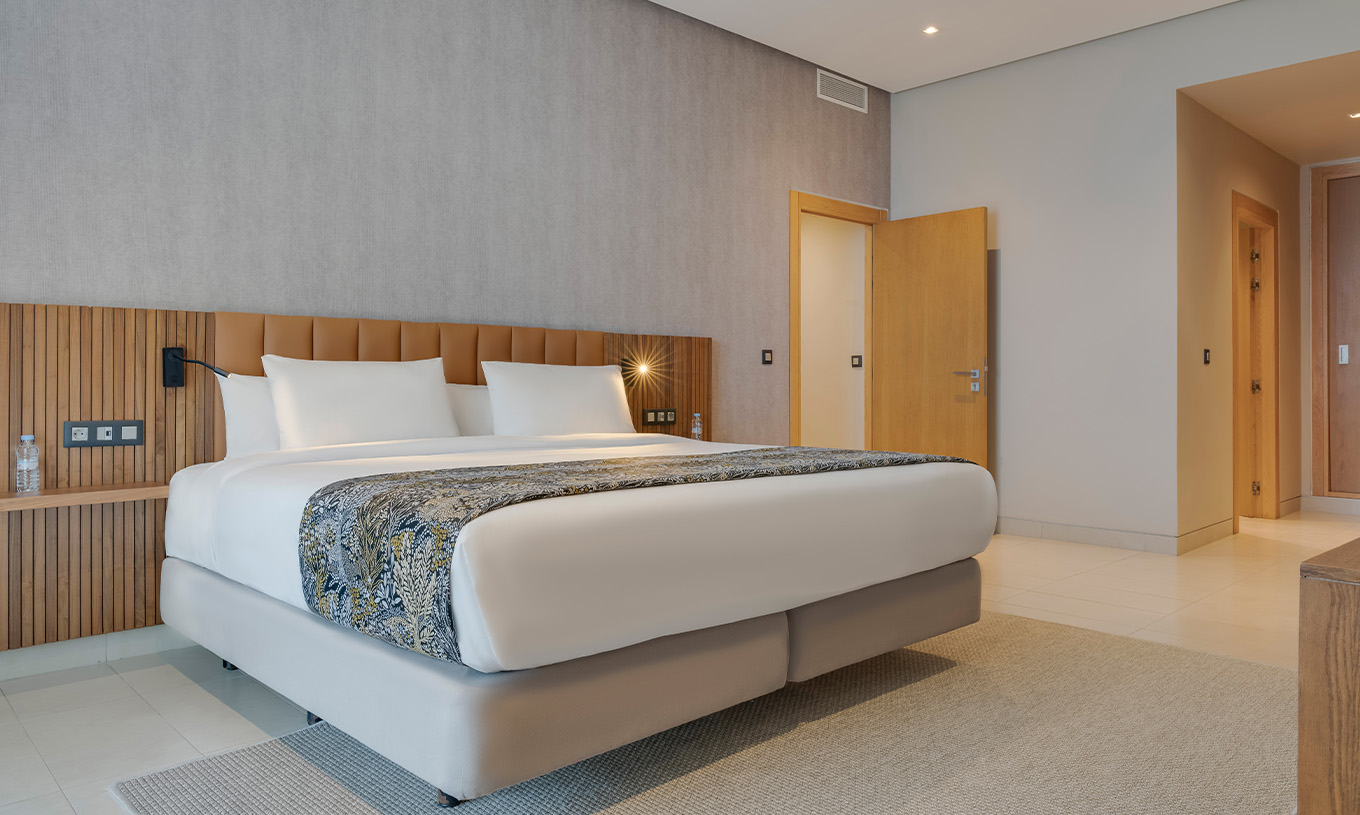 The Family Suite at Pestana Casablanca has a spacious bedroom with a double bed and modern decor