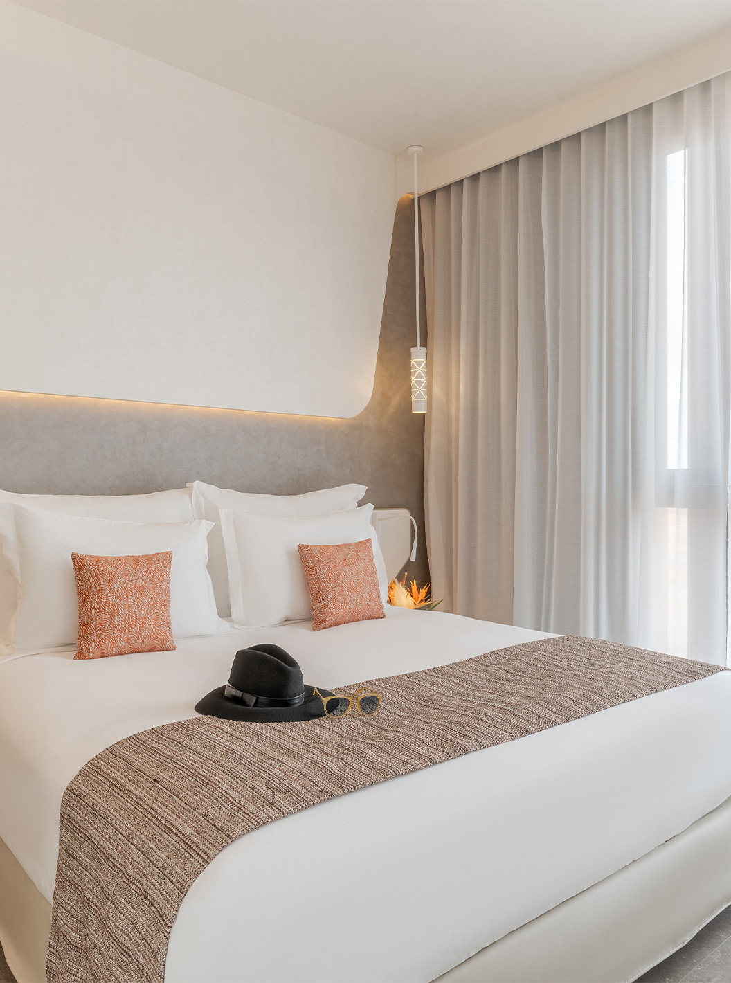 CR7 Junior Suite Avenue at Pestana CR7 Marrakech featuring a bright bed with cushions beside tall curtains